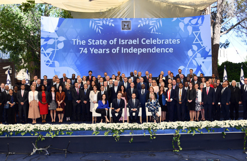 President Herzog, Foreign Minister Lapid, and both their wives pose for a picture with the diplomatic and consular staff stationed in Israel from all around the world.  (credit: CHAIM TZACH/GPO)