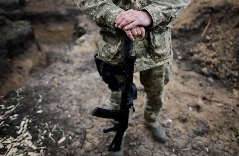  Vitalii, a Ukrainian Army officer, holds his weapon in a trench during tactical exercises at a military camp, amid Russia's invasion of Ukraine, in the Zaporizhzhia region, Ukraine April 30, 2022.  (photo credit: REUTERS/UESLEI MARCELINO)