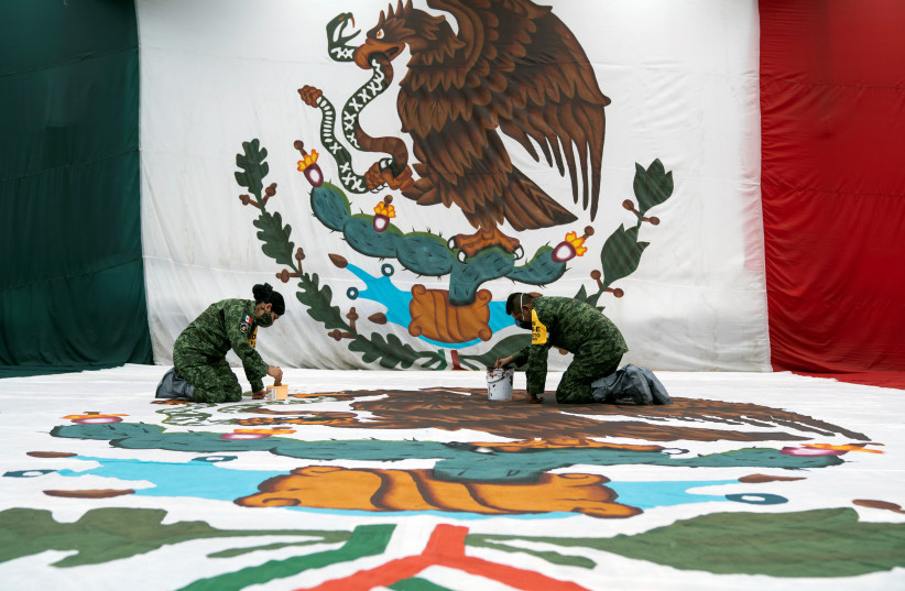 Military personnel paint a monumental Mexican flag at the military clothing and equipment factory El Vergel ahead of Flag Day in Mexico City, Mexico, February 23, 2022. (photo credit: REUTERS/TOYA SARNO JORDAN)
