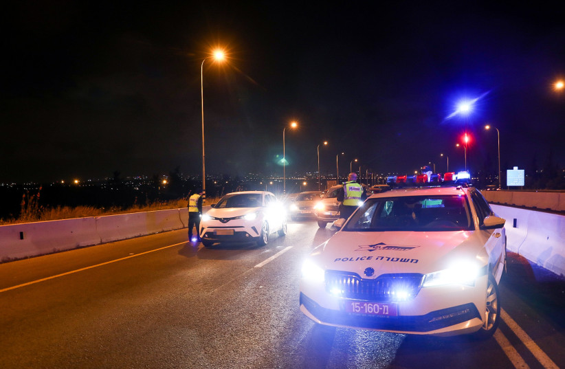  Israeli police officers at a temporary police checkpoint, during the search for the terrorist who murdered three people earlier tonight, near Elad, May 5, 2022. (photo credit: YOSSI ALONI/FLASH90)