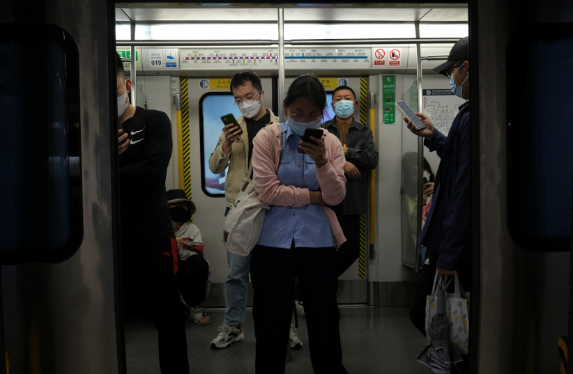  People ride on a subway train during morning rush hour amid the coronavirus disease (COVID-19) outbreak in Beijing, China May 6, 2022.  (credit: REUTERS/TINGSHU WANG)