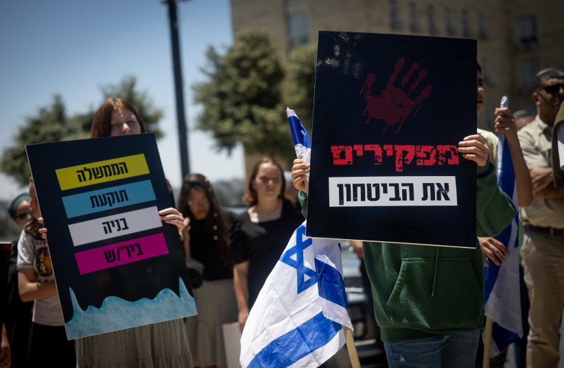 Right-wing activist protest against the government plan to cut down the number of new housing units planned to be built on the West Bank, outside the Prime Minister's Office in Jerusalem, May 8, 2022. (credit: YONATAN SINDEL/FLASH90)