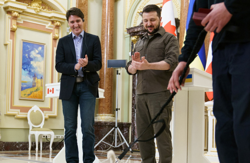  Canada's Prime Minister Justin Trudeau and Ukraine's President Volodymyr Zelensky applaud service dog "Patron" during a news conference, as Russia's attack on Ukraine continues, in Kyiv, Ukraine May 8, 2022. Picture taken May 8, 2022.  (photo credit: Adam Scotti/Prime Minister's Office/Handout via REUTERS)