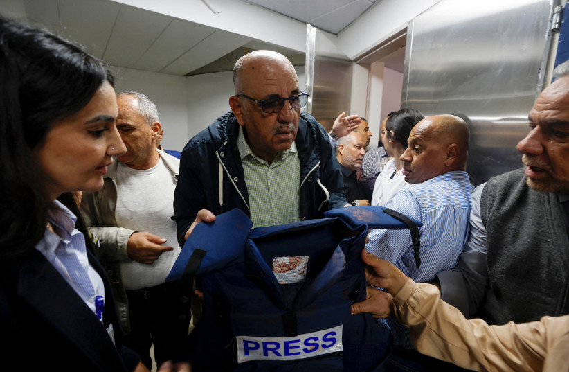  Walid Al-Omari, Al Jazeera's Palestine bureau Chief, holds the flak jacket that reporter Shireen Abu Aqla was wearing when she was killed by gunfire during clashes between Palestinians and IDF in Jenin.  (photo credit: REUTERS/MOHAMAD TOROKMAN)