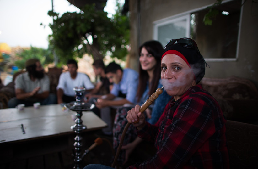  Palestinians and Jewish Israelis sit around a table and smoke hookah on July 22, 2015. (credit: NATI SHOHAT/FLASH90)