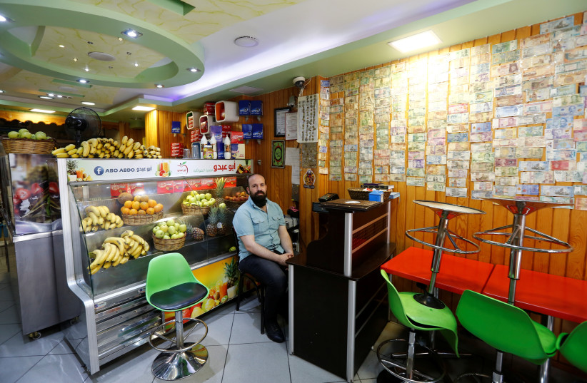  Ahmed, a 40-year old Syrian man from Damascus, selling fruit juice is pictured at his shop in Istanbul, Turkey May 24, 2021. Picture taken May 24, 2021. (credit: REUTERS/DILARA SENKAYA)
