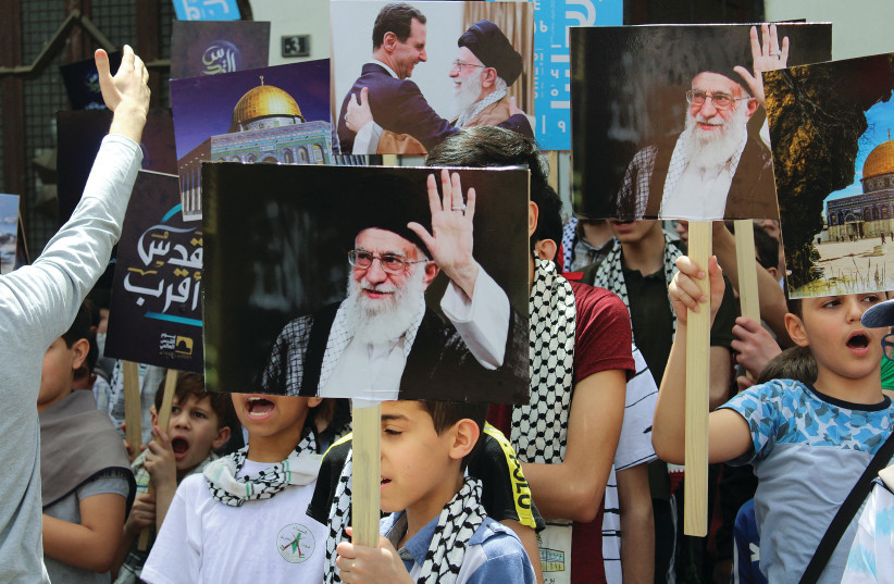  BOYS HOLD pictures depicting Iranian Supreme Leader Ayatollah Ali Khamenei and Syria’s President Bashar Assad as they mark the annual al-Quds Day (Jerusalem Day) in Damascus on April 29.  (photo credit: FIRAS MAKDESI/REUTERS)