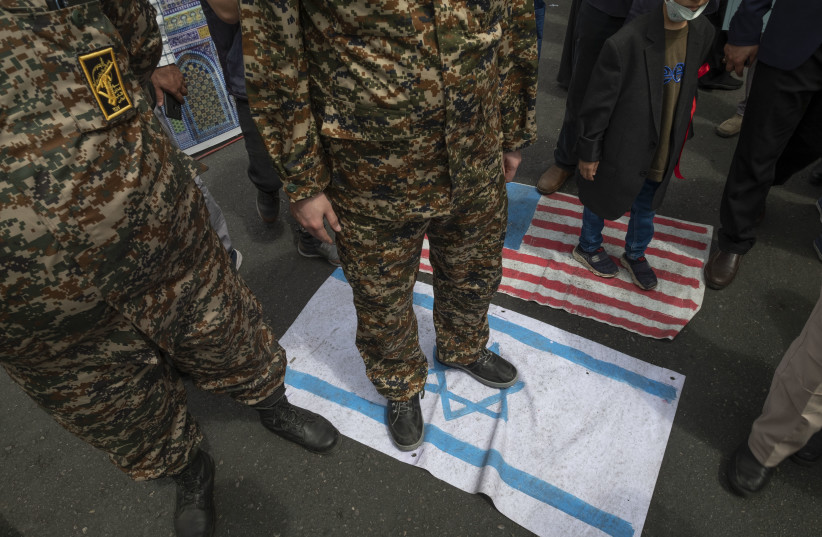 IRGC military personnel stand on Israeli and American flags during a rally commemorating the International Quds Day, in downtown Tehran, April 29, 2022. (credit: Morteza Nikoubazl/NurPhoto via Getty Images)