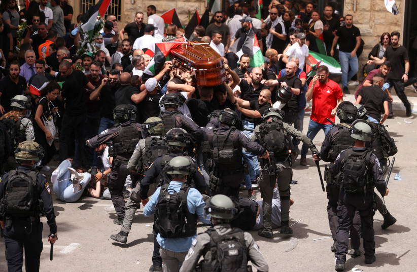 Affrontement de la police avec des personnes en deuil lors des funérailles de Shireen Abu Alkeh à Jérusalem le 13 mai 2022 (crédit photo : REUTERS/AMMAR AWAD)