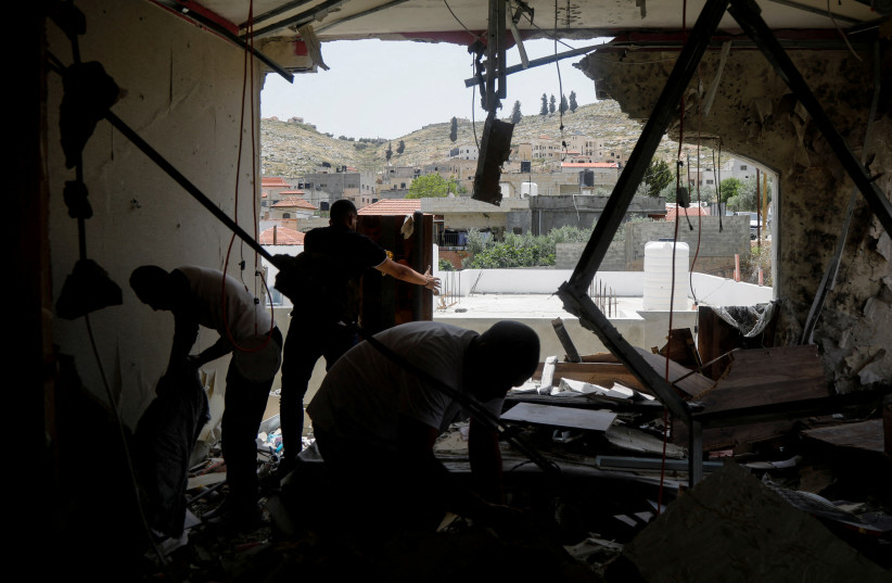 People inspect the destroyed house of a Palestinian suspected terrorist following an Israeli raid, in Jenin, on May 13, 2022.  (credit: REUTERS/RANEEN SAWAFTA)