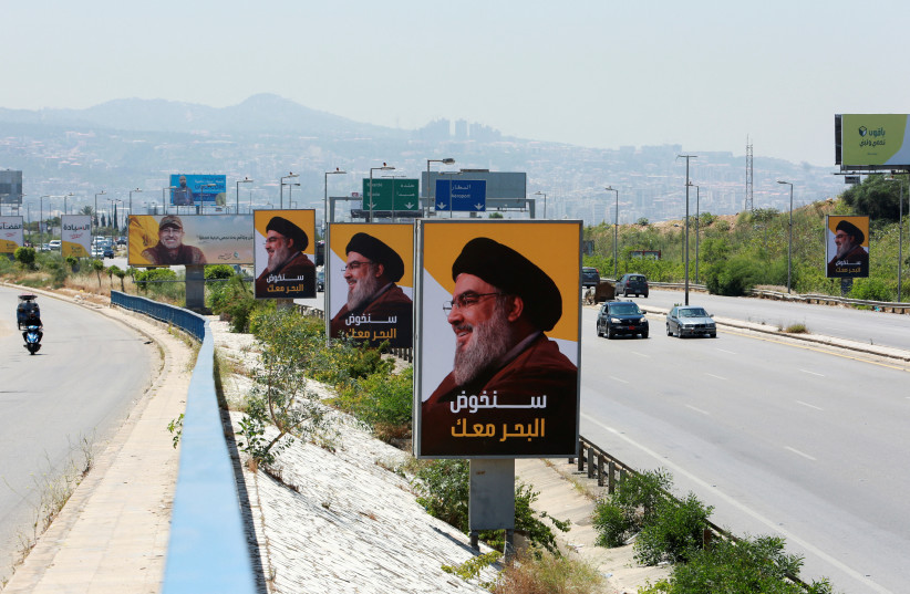 Vehicles drive past billboards depicting Lebanon's Hezbollah leader Sayyed Hassan Nasrallah, ahead of parliamentary election, in Beirut, Lebanon, May 13, 2022. (credit: REUTERS/AZIZ TAHER)