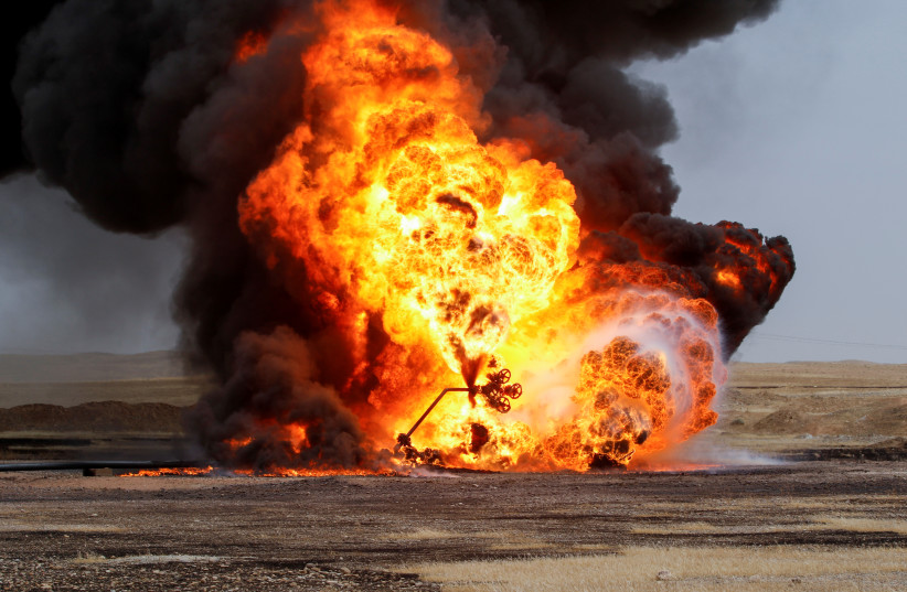 Flames and smoke rise from oil wells inside the Bai Hassan oilfield, which was attacked by militants, close to the northern Iraqi city of Kirkuk, Iraq, May 5, 2021. (credit: REUTERS/AKO RASHEED)