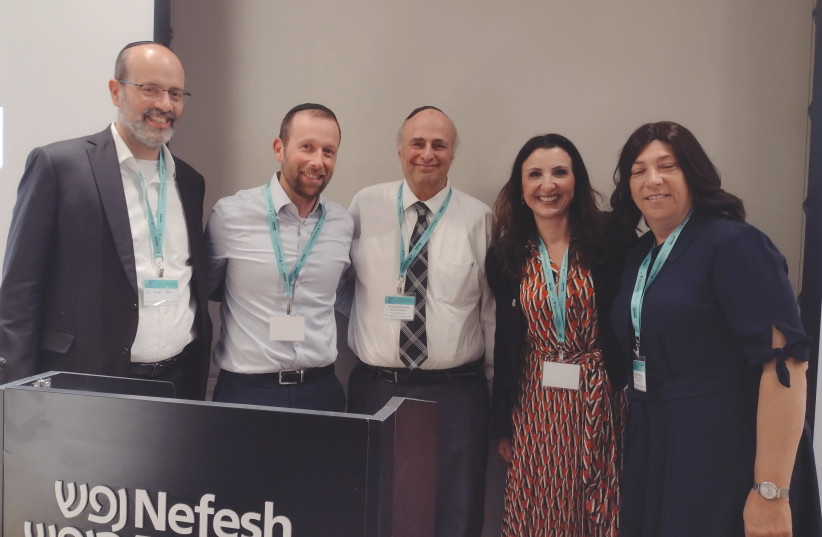  Dr. Ariel Kor, Dr. Shmuel Harris, Dr. David Pelcovitz, Fleur Hassan-Nahoum and Stephanie Strauss pose for a photo at yesterday’s conference. (photo credit: Debbie Rapps)