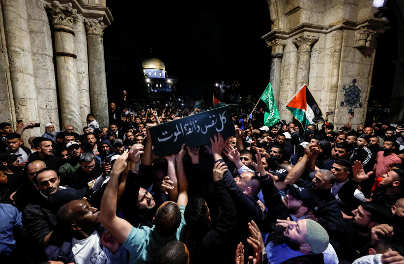 People mourn as they carry the coffin of Walid al-Sharif during his funeral on the compound that houses Al-Aqsa Mosque, known to Muslims as Noble Sanctuary and to Jews as Temple Mount, in Jerusalem's Old City May 16, 2022 (credit: REUTERS/AMMAR AWAD)