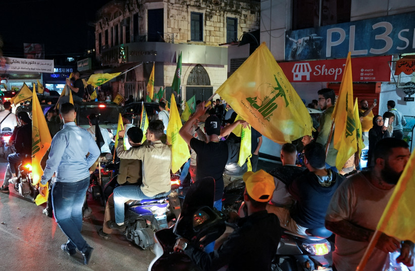 Supporters of Lebanon's Hezbollah leader Sayyed Hassan Nasrallah and Amal Movement carry flags while riding in a convoy as votes are being counted in Lebanon's parliamentary election, in Nabatiyeh, southern Lebanon, May 15, 2022. (photo credit: REUTERS/ISSAM ABDALLAH)