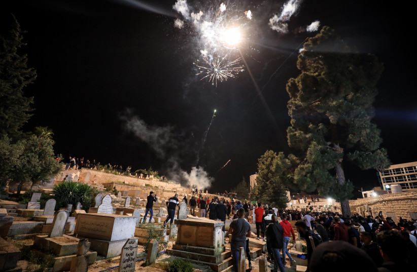  Palestinians shot fireworks at Israeli police during the funeral of Walid al-Sharif, outside Jerusalem Old City on May 16, 2022. (credit: JAMAL AWAD/FLASH90)