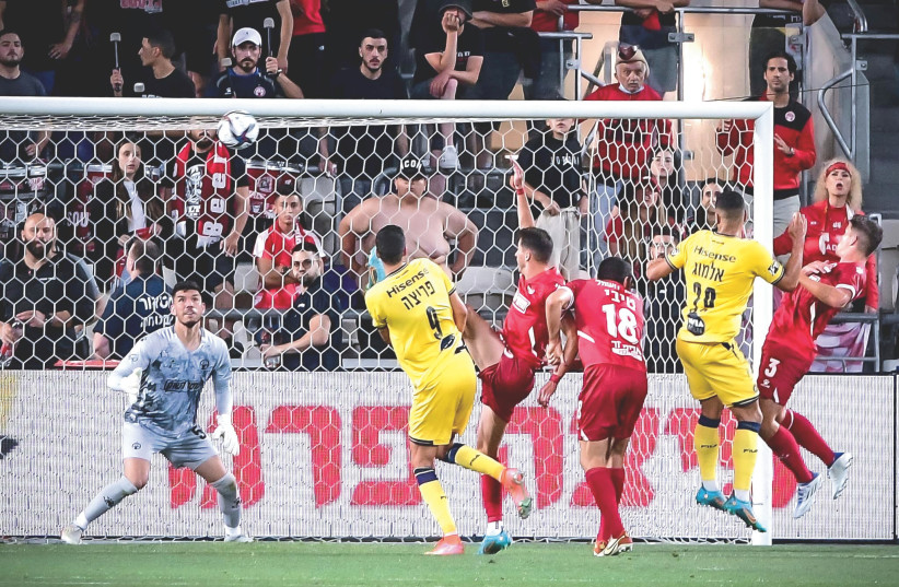 The result of Monday night’s 1-1 draw between Maccabi Tel Aviv (in yellow) and Hapoel Beersheba (in red) clinched the Israel Premier League title for Maccabi Haifa  (photo credit: ARIEL SHALOM)