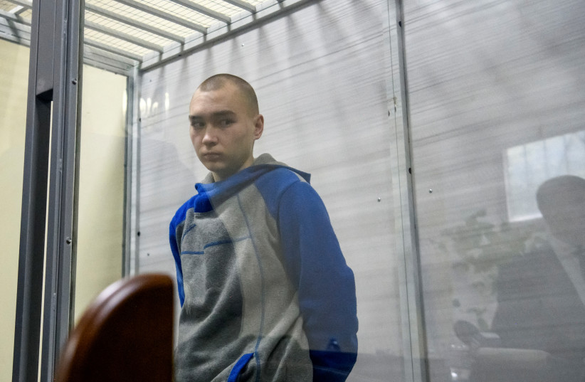  Russian soldier Vadim Shishimarin, 21, suspected of violations of the laws and norms of war, is seen inside a defendants' cage during a court hearing, amid Russia's invasion of Ukraine, in Kyiv, Ukraine May 18, 2022. (photo credit: REUTERS/VLADYSLAV MUSIIENKO)