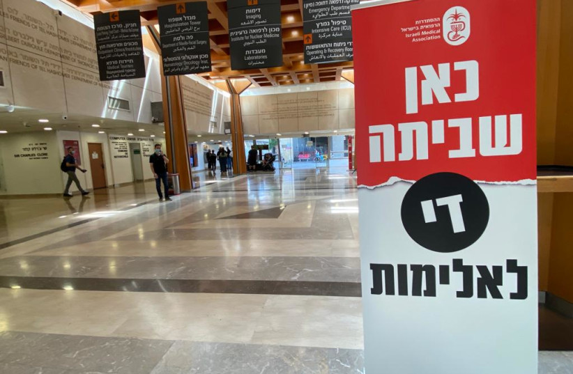  A sign reading "here we are striking, stop the violence" can be seen in a hallway at Sheba Medical Center, Tel Hashomer in response to violence against medical staff, May 19, 2022 (photo credit: AVSHALOM SASSONI/MAARIV)