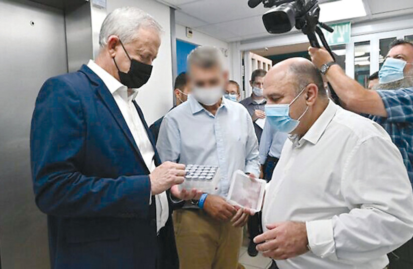  Defense Minister Benny Gantz, left, speaks with then-director of the Institute of Biological Research, Prof. Shmuel Shapira, at the center’s laboratory in Ness Ziona, last year. (credit: ARIEL HERMONI / DEFENSE MINISTRY)