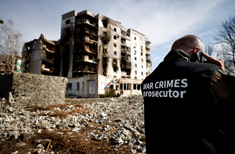  War crime prosecutor's team member speaks on the phone next to buildings that were destroyed by Russian shelling, amid Russia's Invasion of Ukraine, in Borodyanka, Kyiv region, Ukraine April 7, 2022 (photo credit: REUTERS/ZOHRA BENSEMRA)