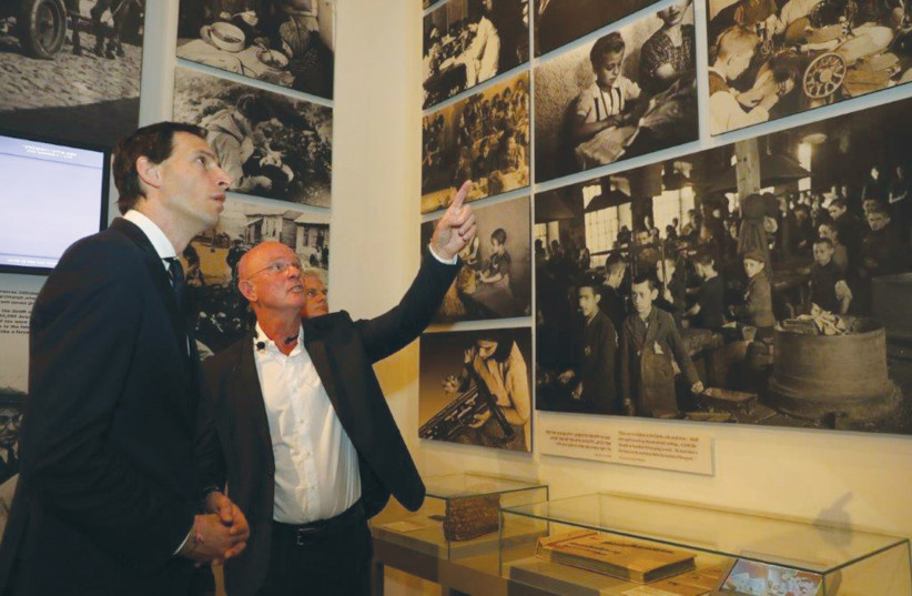  DUTCH FOREIGN MINISTER Wopke Hoekstra, accompanied by a Yad Vashem guide, views photographs of children that were documented during the Holocaust.  (photo credit: ISAAC HARARI/YAD VASHEM)