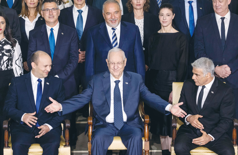  THEN-PRESIDENT Reuven Rivlin is flanked in the front row by Prime Minister Naftali Bennett and Foreign Minister Yair Lapid for a group photo of the newly inaugurated government last June.  (photo credit: YONATAN SINDEL/FLASH90)
