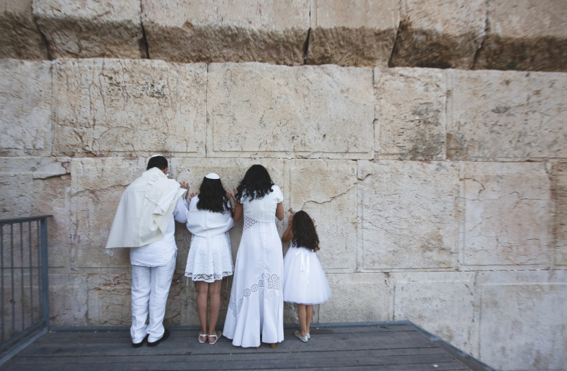  A FAMILY prays at the section of the Kotel designated for non-Orthodox worship. (photo credit: MARC ISRAEL SELLEM/THE JERUSALEM POST)