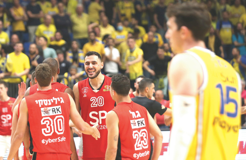   IDAN ZALMANSON (20) and Hapoel Tel Aviv players celebrate after their 93-75 victory over city rival Maccabi Tel Aviv in Game 3 of their best-of-five quarterfinal series. (photo credit: UDI ZITIAT)