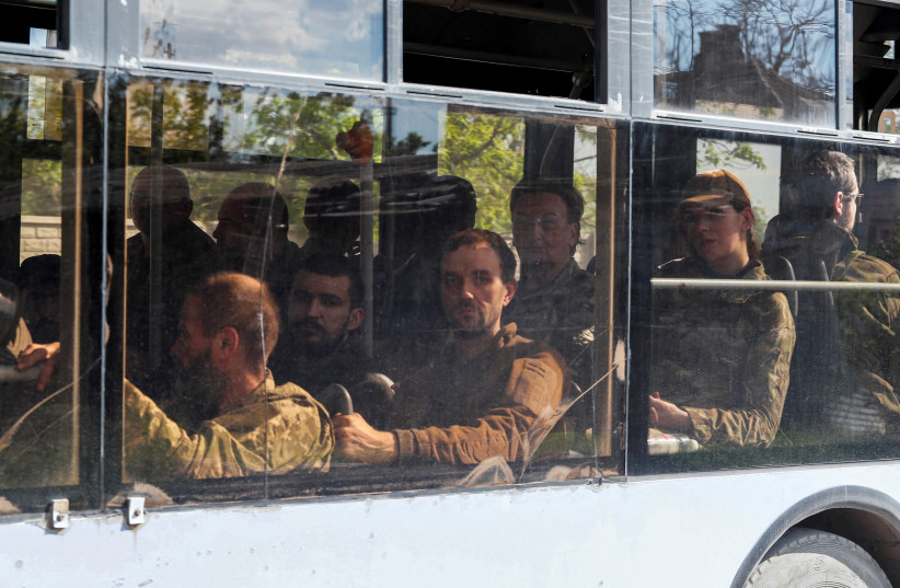  A bus carrying service members of the Ukrainian armed forces, who surrendered at the besieged Azovstal steel mill, drives away under escort of the pro-Russian military in the course of the Ukraine-Russia conflict, in Mariupol, Ukraine May 20, 2022. (credit: REUTERS/ALEXANDER ERMOCHENKO)
