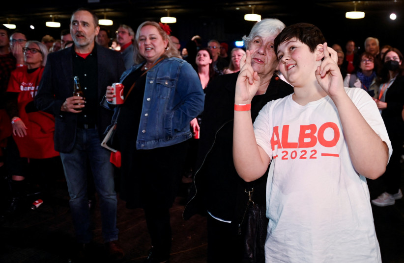  Supporters react to election updates on the vote count on a big screen broadcasting these updates while they wait for Anthony Albanese, leader of Australia's Labor Party, to speak about the outcome of the country's general election. (credit: JAIMI JOY/REUTERS)