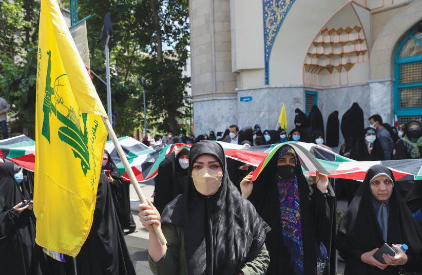  AN IRANIAN woman holds a Hezbollah flag during a rally in Tehran in support of the Palestinians, last year. (photo credit: WEST ASIA NEWS AGENCY)