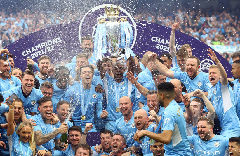 Manchester City's Fernandinho lifts the trophy as he celebrates with teammates after winning the Premier League, Etihad Stadium, Manchester, Britain, May 22, 2022 . (photo credit: REUTERS/HANNAH MCKAY)