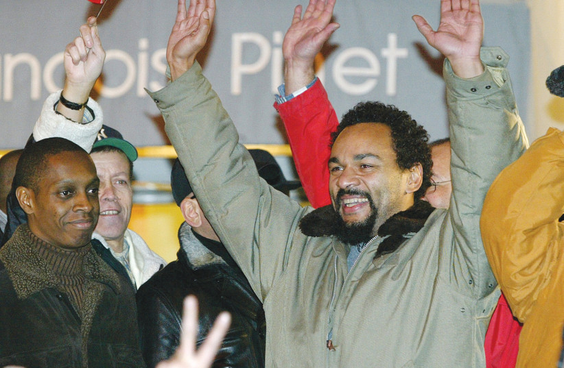  DIEUDONNE M’BALA M’BALA raises hands with fans near a Paris theater, which canceled his show in February 2004 fearing his performance would spark protests by anti-racist and Jewish groups.  (photo credit: John Schults/Reuters)