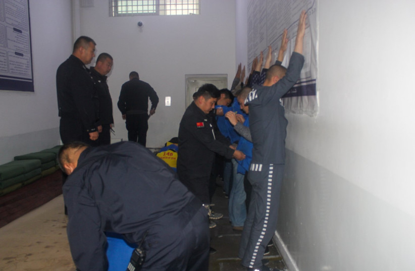  An image taken from the Xinjiang Police Files showing security guards searching prisoners in what researchers presume was a drill (photo credit: VICTIMS OF COMMUNISM MEMORIAL FOUNDATION)