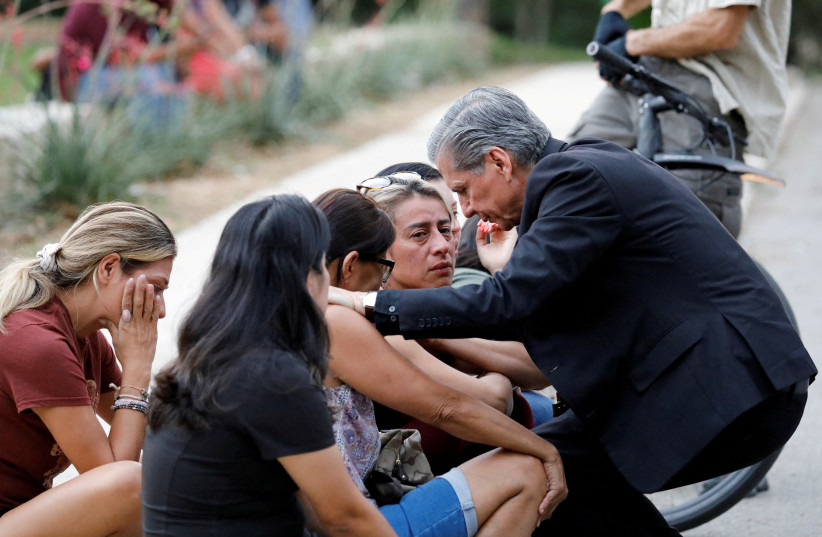  Gustavo Garcia-Siller, Archbishop of the Archdiocese of San Antonio, comforts people as they react outside the Ssgt Willie de Leon Civic Center, where students had been transported from Robb Elementary School after a shooting, in Uvalde, Texas, US May 24, 2022. (photo credit: REUTERS/MARCO BELLO)