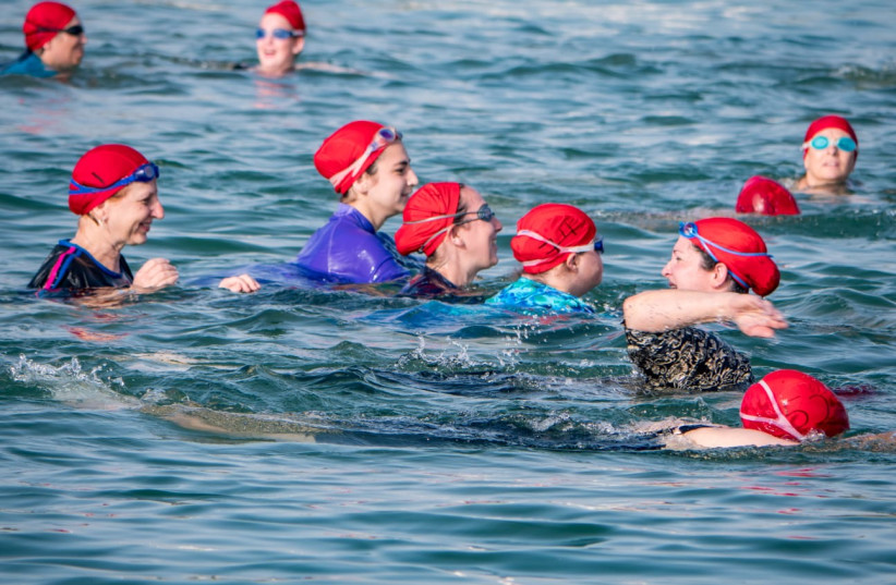 Women begin their swim across the Kinneret in the annual 'Swim4Sadna' event that raises funds for a center for people with disabilities.   (photo credit: LAURA BEN-DAVID)