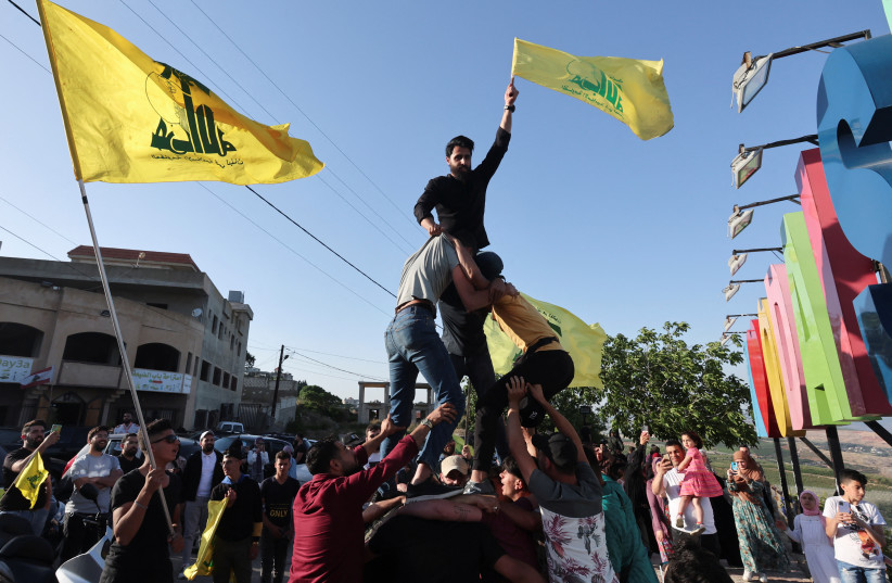  Supporters of Lebanon's Hezbollah leader Sayyed Hassan Nasrallah, gather as they carry flags, marking the commemoration of Israel's withdrawal from southern Lebanon in 2000, in Adaisseh village near the border with Israel, southern Lebanon, May 25, 2022.  (credit: REUTERS/AZIZ TAHER)