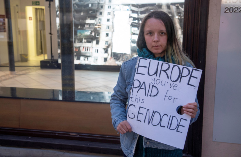  A woman displays a poster in front of the Russian War Crimes House during the World Economic Forum 2022 (WEF) in the Alpine resort of Davos, Switzerland May 25, 2022.  (photo credit: REUTERS)