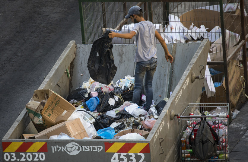  STILL A very poor city: Searching through trash for cans to redeem. (credit: NATI SHOHAT/FLASH90)