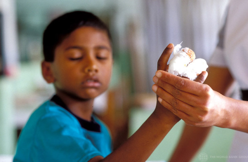  Young boy receiving bandages for his injured hand. (photo credit: FLICKR)