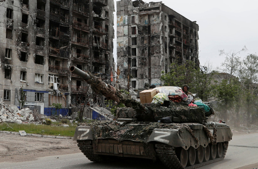  Service members of pro-Russian troops drive a tank along a street past a destroyed residential building during Ukraine-Russia conflict in the town of Popasna in the Luhansk Oblast, Ukraine May 26, 2022.  (credit: Alexander Ermochenko/Reuters)