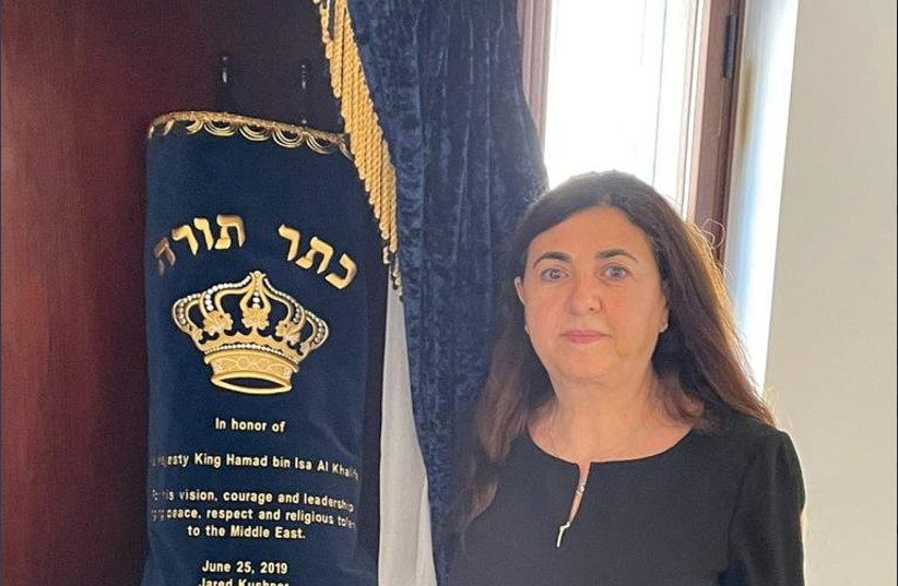  THE WRITER poses with a Torah scroll that Jared Kushner, senior aide to former president Donald Trump, commissioned in honor of King Hamad bin Isa Al Khalifa and which is currently in the House of Ten Commandments synagogue. (photo credit: HOUSE OF THE TEN COMMANDMENTS)