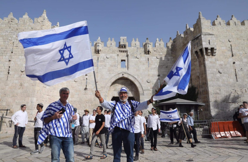 People hold up Israeli flags at the annual Jerusalem Day flag march. (credit: MARC ISRAEL SELLEM)