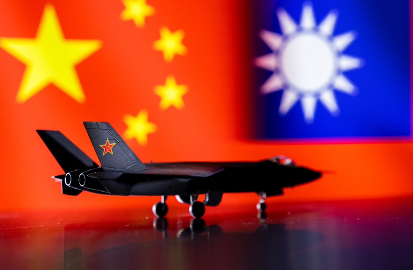  A model of the Chinese Fighter aircraft is seen in front of Chinese and Taiwanese flags in this illustration taken, April 28, 2022. Picture taken April 28, 2022 (photo credit: REUTERS/DADO RUVIC)