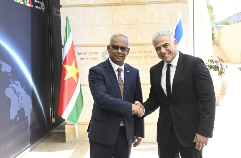  Surinamese Foreign Minister Albert Ramdin and Israeli Foreign Minister Yair Lapid are seen shaking hands in Jerusalem, on May 30, 2022. (photo credit: JORGE NOVOMINSKY/FOREIGN MINISTRY)
