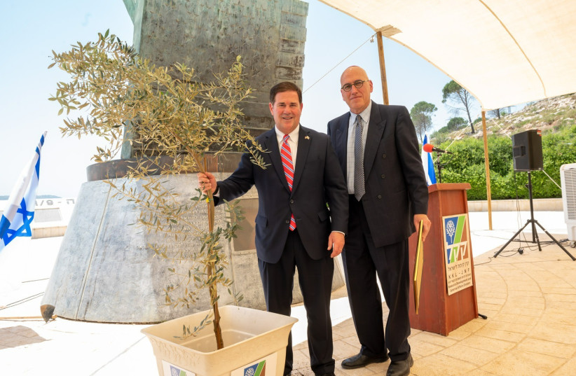 Arizona Gov. Doug Ducey (left) and KKL – JNF Vice Chairman Yair Lootsteen stand next to the olive tree planted by the governor at the 9/11 Living Memorial in Arazim Valley, Jerusalem, May 30, 2022. (credit: KKL-JNF)