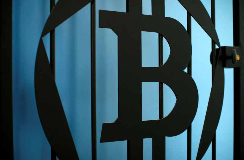   The logo of bitcoin is pictured on a door in an illustration picture taken at La Maison du Bitcoin in Paris July 11, 2014. (credit: REUTERS/Benoit Tessier/File Photo)