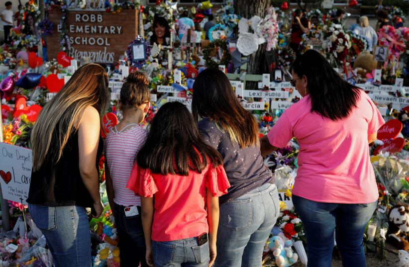  People pay their respects at the Robb Elementary School memorial, where a gunman killed 19 children and two teachers in the deadliest US school shooting in nearly a decade, in Uvalde, Texas, US May 30, 2022.  (credit: REUTERS/MARCO BELLO)