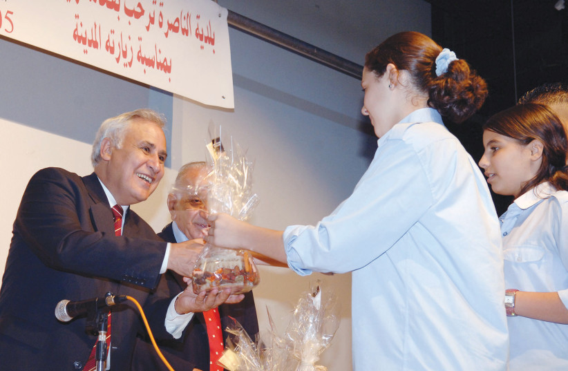  THEN-PRESIDENT Moshe Katsav receives a gift from high school students on a visit to Nazareth in 2005. (credit: AMOS BEN-GERSHOM/GPO)